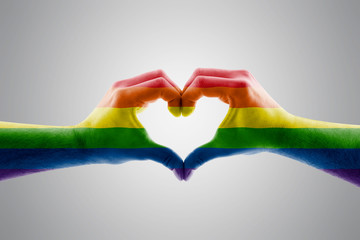 Two hands in the form of LGBT rainbow heart symbol of love