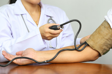 Doctor checking blood pressure of a patient at hospital, Medicine concept