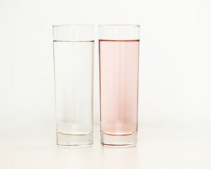 Two glasses of rose and transparent liquid on white background, São Paulo, Brazil