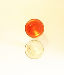 Two glasses of red and transparent liquid on white background, São Paulo, Brazil