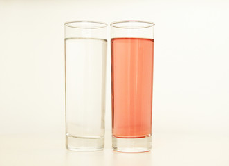 Two glasses of red and transparent liquid on white background, São Paulo, Brazil