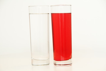 Two glasses of red and transparent liquid on white background, São Paulo, Brazil