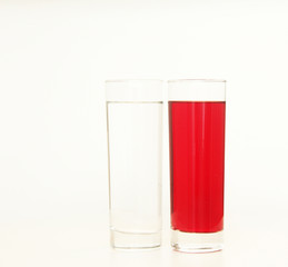 Two glasses of red and transparent liquid on white background, São Paulo, Brazil