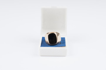 Male golden ring with black stone in a box isolated on a white background