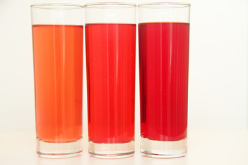 Three glasses of red and transparent liquid on white background, São Paulo, Brazil