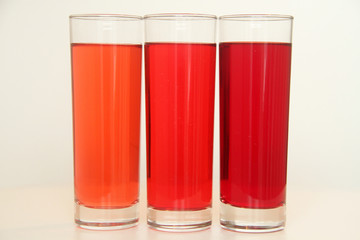 Three glasses of red and transparent liquid on white background, São Paulo, Brazil