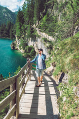 man walking by hiking trail around braies lake in italy dolomites mountains