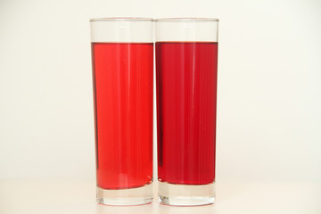 Two glasses of red and transparent liquid on white background, São Paulo, Brazil
