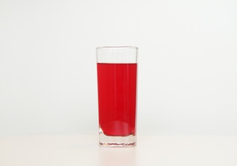 One glass of red  liquid on white background, São Paulo, Brazil