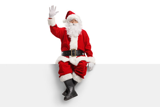 Santa claus sitting on a panel and waving