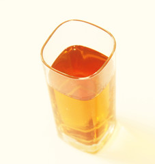 One glass of yellow and transparent liquid on white background, São Paulo, Brazil