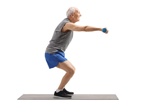 Senior man exercising squats and holding dumbbells