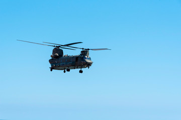 Naklejka na ściany i meble Sidmouth, Devon, England, July 2019. A RAF Chinook heavy lift helicopter flying along the south west coast at Sidmouth, Devon, UK