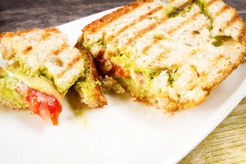 Guacamole and bread. Toast with avocado and tomatoes on white plate. Mobile photography.