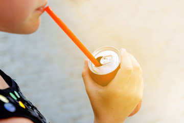 Tanned girl drinks carbonated soft drink.