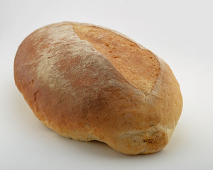 Top view on rustic bread on a white background. Home baked bread isolated on natural textured background. Oval homemade bread. Fresh bakery image with copy space for your text.