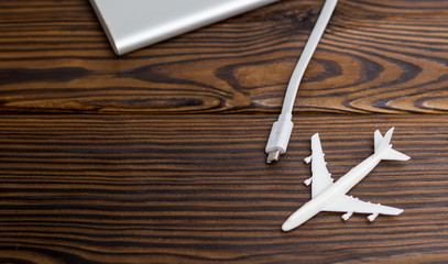 Plane and battery on dark wooden background. Electric plane or green plane concept.