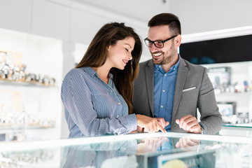 Middle age couple enjoying in shopping at modern jewelry store.