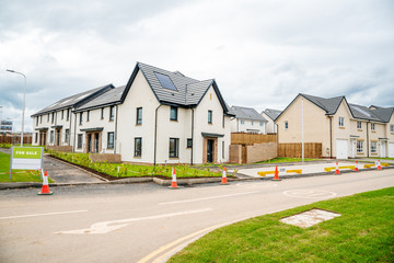 Fototapeta na wymiar Newly built energy efficient houses with solar panels on the roof on sale in a housing estate in UK