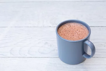  Hot chocolate in a blue-grey ceramic mug isolated on white painted wood. Space for text. © Moving Moment