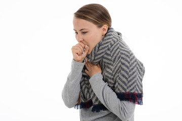 Young sick woman wrapped in a scarf on white background. Cold, flu, illness.