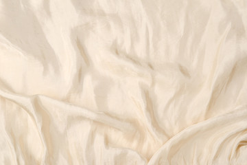 Soft smooth beige silk fabric background. Fabric texture.