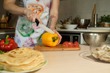 Girl cook makes cutting vegetables for tasty and juicy tortilla