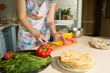 Girl cook makes cutting vegetables for tasty and juicy tortilla