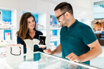 Obraz premium Middle age couple enjoying in shopping at modern jewelry store.