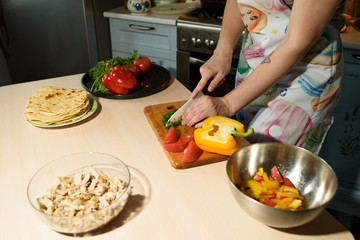 Girl cook makes cutting vegetables for tasty and juicy tortilla