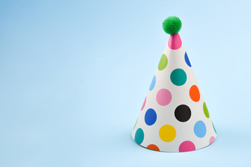Colorful birthday cap on a blue background. Copy space.