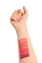 Lipstick swatches on woman hand isolated on white background.
