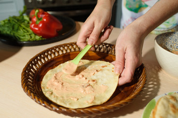 Girl cook cooks delicious tortilla pork and fresh vegetables