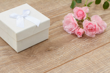Gift box with rose flowers on the background.
