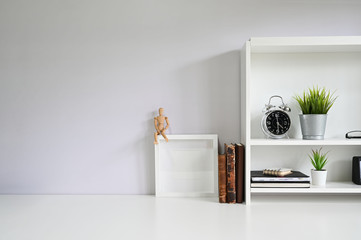 Copy space with books, alarm on white table.