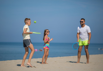 Summer holidays. Sport. Lifestyle. Father with children playing tennis