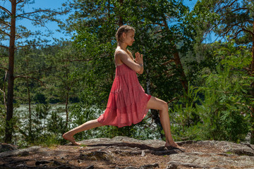 young beautiful woman in dress doing yoga outdoors. Healthy lifestyle concept.