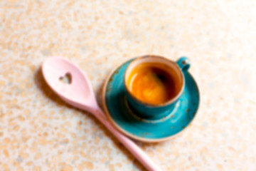 Modern blue coffee cup with wooden pink spoon with a heart in Cafe. View from above with copy space and pink toned. Creative inspiration