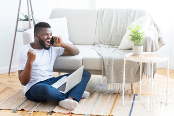 Happy black man hearing good news on phone