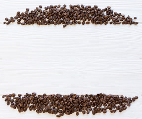Roasted coffee beans on white wooden background, top view. Copy space, free place for text