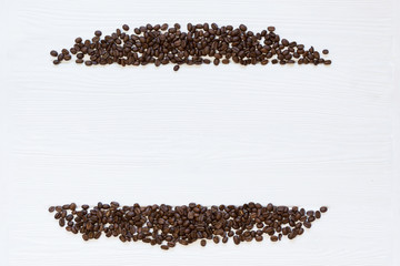 coffee beans stripes on white wooden background, vertical. Copy space, free place for text