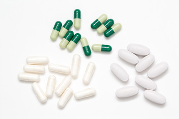 Green and white capsules pills  closeup isolated on white background