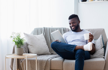 Obraz premium African american man watching movie on tablet