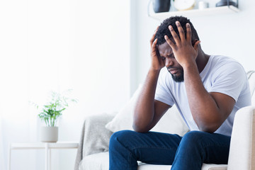 African-american man suffering from headache at home