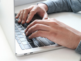 Fototapeta na wymiar White man typing on a laptop keyboard 