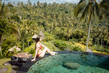 Woman in red bikini enjoying the tropical pool