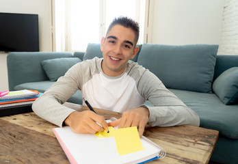 Closeup of a happy, cheerful young man studying, working in homework. Learning from books at home