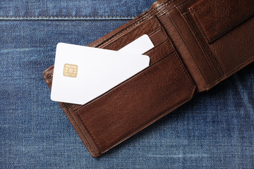 Blank white credit cards in leather wallet on denim background. Flat lay.