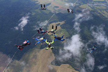 Skydiving. A group of skydivers is in the sky.