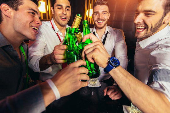 Group Of Young Men Toasting At A Nightclub